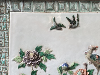 A Chinese relief-decorated famille verte 'peacock' plaque in a fine carved hongmu wooden frame, 19th C.