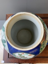 A pair of Chinese powder-blue-ground famille verte vases and covers, 19th C.