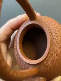Een Chinese Yixing steengoed theepot met gekerfd decor van chrysanten, Kangxi