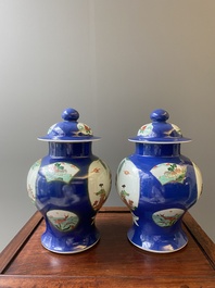 A pair of Chinese powder-blue-ground famille verte vases and covers, 19th C.