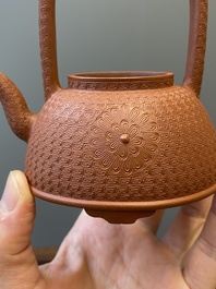 Een Chinese Yixing steengoed theepot met gekerfd decor van chrysanten, Kangxi
