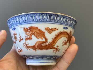 A Chinese blue, white and iron-red 'dragon' bowl and cover and a wine cup, Qianlong mark, 18/19th C.