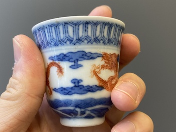 A Chinese blue, white and iron-red 'dragon' bowl and cover and a wine cup, Qianlong mark, 18/19th C.