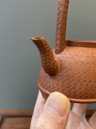 Een Chinese Yixing steengoed theepot met gekerfd decor van chrysanten, Kangxi