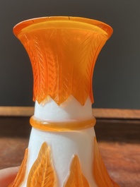A Chinese overlay Beijing glass bottle vase with lotus scrolls in yellow on white, 19t/20h C.