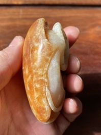 Een Chinese witte en roestkleurige jade hanger in de vorm van een buffel, 19e eeuw