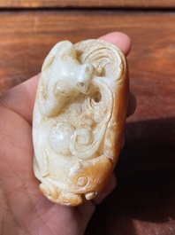 Een Chinese witte en roestkleurige jade hanger in de vorm van een buffel, 19e eeuw