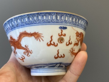 A Chinese blue, white and iron-red 'dragon' bowl and cover and a wine cup, Qianlong mark, 18/19th C.