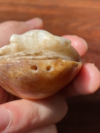 Een Chinese witte en roestkleurige jade hanger in de vorm van een buffel, 19e eeuw
