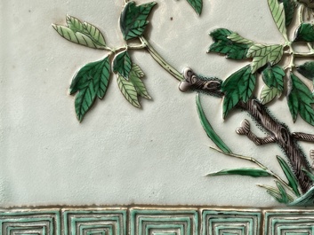 A Chinese relief-decorated famille verte 'peacock' plaque in a fine carved hongmu wooden frame, 19th C.