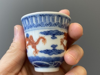 A Chinese blue, white and iron-red 'dragon' bowl and cover and a wine cup, Qianlong mark, 18/19th C.