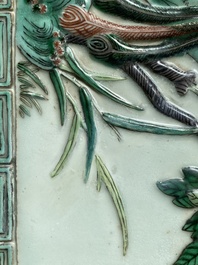 A Chinese relief-decorated famille verte 'peacock' plaque in a fine carved hongmu wooden frame, 19th C.