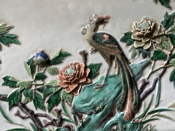 A Chinese relief-decorated famille verte 'peacock' plaque in a fine carved hongmu wooden frame, 19th C.