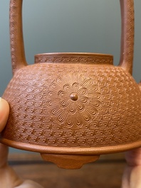 Een Chinese Yixing steengoed theepot met gekerfd decor van chrysanten, Kangxi