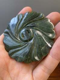 Un disque 'bi' en jade c&eacute;ladon et rouille et un pendentif en forme de fleur en jade vert sur socles en bois, Ming et Qing