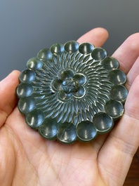 Un disque 'bi' en jade c&eacute;ladon et rouille et un pendentif en forme de fleur en jade vert sur socles en bois, Ming et Qing