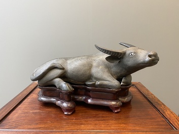 Een grote Chinese grisaille sculptuur van een liggende buffel op houten sokkel, 18/19e eeuw