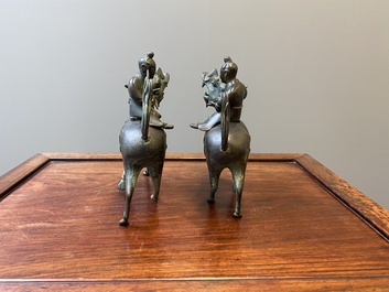 Een paar Chinese bronzen wierookbranders in de vorm van jongens op kylins, Ming
