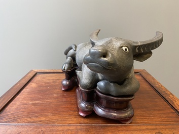 Een grote Chinese grisaille sculptuur van een liggende buffel op houten sokkel, 18/19e eeuw