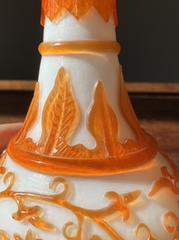 A Chinese overlay Beijing glass bottle vase with lotus scrolls in yellow on white, 19t/20h C.