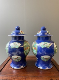 A pair of Chinese powder-blue-ground famille verte vases and covers, 19th C.