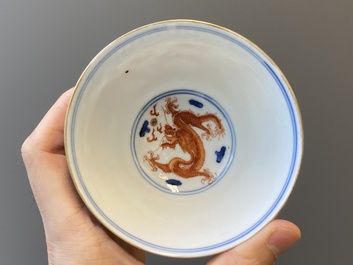 A Chinese blue, white and iron-red 'dragon' bowl and cover and a wine cup, Qianlong mark, 18/19th C.
