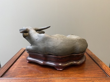 Een grote Chinese grisaille sculptuur van een liggende buffel op houten sokkel, 18/19e eeuw
