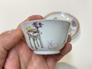 A pair of Chinese famille rose cups and saucers with a lady and a boy, Yongzheng