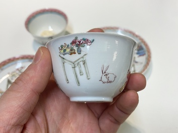 A pair of Chinese famille rose cups and saucers with a lady and a boy, Yongzheng