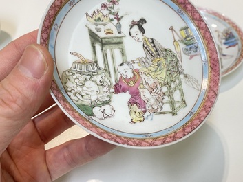 A pair of Chinese famille rose cups and saucers with a lady and a boy, Yongzheng