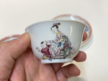 A pair of Chinese famille rose cups and saucers with a lady and a boy, Yongzheng