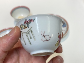 A pair of Chinese famille rose cups and saucers with a lady and a boy, Yongzheng