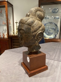 Een Chinees bruin-grijs kalkstenen hoofd van Bodhisattva, wellicht Tang