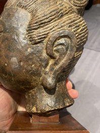 Een Chinees bruin-grijs kalkstenen hoofd van Bodhisattva, wellicht Tang