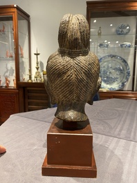 Een Chinees bruin-grijs kalkstenen hoofd van Bodhisattva, wellicht Tang