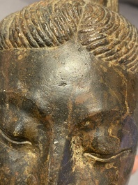 Een Chinees bruin-grijs kalkstenen hoofd van Bodhisattva, wellicht Tang