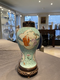Een Chinese famille rose vaas met turquoise fondkleur met opengewerkt houten deksel en sokkel, 1e helft 19e eeuw