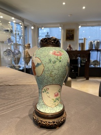 Een Chinese famille rose vaas met turquoise fondkleur met opengewerkt houten deksel en sokkel, 1e helft 19e eeuw