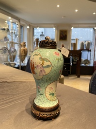 Een Chinese famille rose vaas met turquoise fondkleur met opengewerkt houten deksel en sokkel, 1e helft 19e eeuw