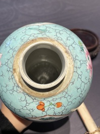 Een Chinese famille rose vaas met turquoise fondkleur met opengewerkt houten deksel en sokkel, 1e helft 19e eeuw