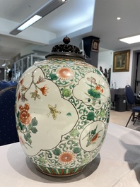 A Chinese famille rose vase and a famille verte jar with wooden cover, 19th C.
