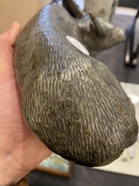 Een Chinese monochrome sculptuur van een liggende waterbuffel op houten sokkel, 19e eeuw