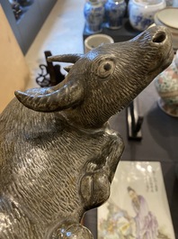 Een Chinese monochrome sculptuur van een liggende waterbuffel op houten sokkel, 19e eeuw