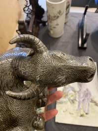Een Chinese monochrome sculptuur van een liggende waterbuffel op houten sokkel, 19e eeuw