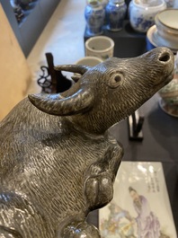 Een Chinese monochrome sculptuur van een liggende waterbuffel op houten sokkel, 19e eeuw
