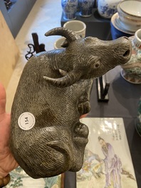 Een Chinese monochrome sculptuur van een liggende waterbuffel op houten sokkel, 19e eeuw