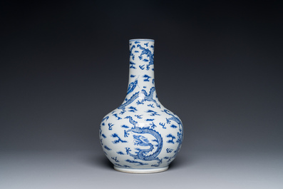 A Chinese blue and white bottle vase with dragons among flames and clouds, 19th C.