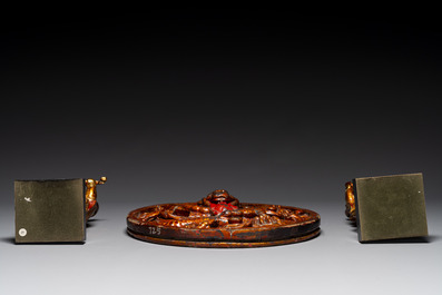 A pair of Chinese gilt-lacquered wooden guardians and a round 'dragon' plaque, 19th C.