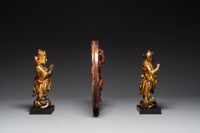 A pair of Chinese gilt-lacquered wooden guardians and a round 'dragon' plaque, 19th C.