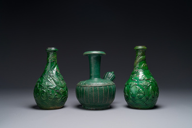 Two Chinese monochrome green-glazed stoneware 'dragon' vases and a kendi, Fujian kiln, late Ming
